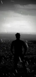 Silhouette of man overlooking city in black and white.