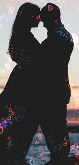 Silhouette of a couple embracing by the ocean at sunset.