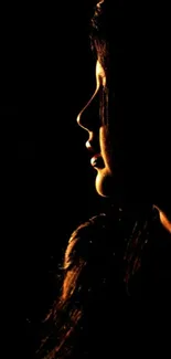 Silhouette of a woman with dramatic lighting on a dark background.