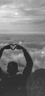 Silhouette forming heart over a cloudy sky with starry effect.