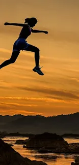 Silhouette of person jumping at sunset over a mountain landscape.