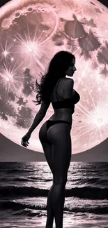 Silhouette of a woman on a moonlit beach with vibrant pink full moon backdrop.