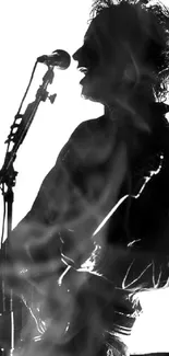 Silhouette of a musician playing guitar on stage in black and white.