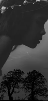 Silhouette of girl with flowers in hair against a gray dramatic sky.