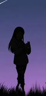 Silhouette of person under a purple night sky.