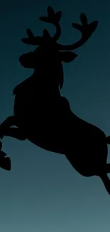 Silhouette of a leaping reindeer against a dark blue night sky.