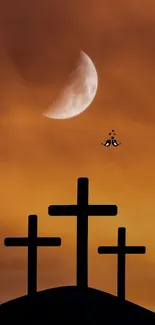 Three crosses silhouette with moon in an orange sky.