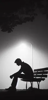 Mobile wallpaper of silhouette on park bench under a streetlight at night.