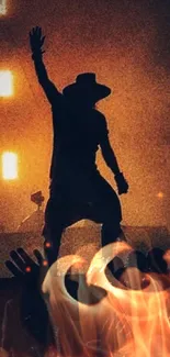 Silhouette of a performer on stage with vibrant orange lights.