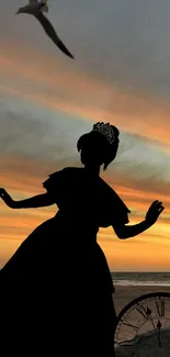 Silhouette of a princess with a stunning sunset sky backdrop on the beach.