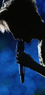 Silhouette of a singer with a blue bokeh background on stage.