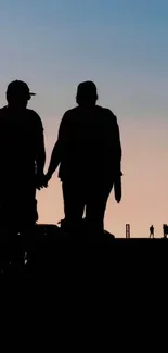 Silhouette couple against sunset sky, creating a picturesque mobile wallpaper.