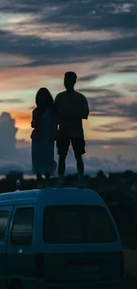 Silhouette of couple on van at sunset with vivid sky.