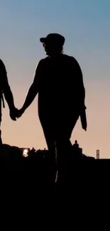 Silhouette of a couple holding hands during a beautiful sunset.