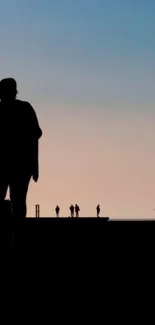 Silhouette figures against a sunset sky wallpaper.