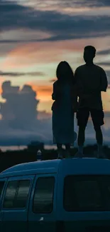 Silhouette of couple standing on a car roof against a sunset sky.