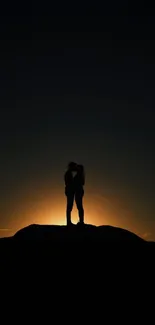 Romantic couple silhouette at sunset with warm glow.