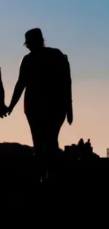 Couple silhouette walking at sunset, peaceful scene.