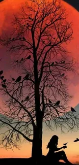 Silhouette tree and orange moon with birds in a night scene.