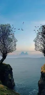 Artistic silhouettes of trees shaped like faces on a cliff at sunset.