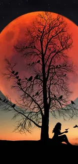 Silhouette of tree and birds against a red moon on a phone wallpaper.