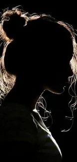 Silhouette of a woman with backlighting, artistic tone.