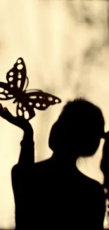 Silhouette of woman with butterfly art on mobile wallpaper.