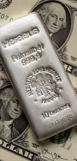 Silver bar resting on dollar bills, showcasing wealth.