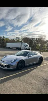 Sleek silver car parked under a bright cloudy sky in picturesque setting.