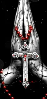 Silver hands holding a red rosary and cross on a black background.