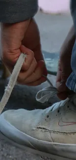 Skater tying shoelace on skateboard ready for action.