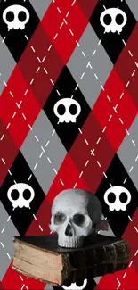 Gothic skull on books with red and black argyle pattern wallpaper.