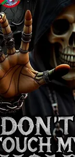 Gothic skull with metallic hand on wallpaper.