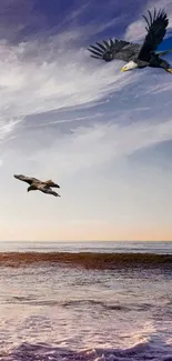 Eagles flying over the ocean with a dramatic blue sky backdrop.