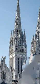 Gothic cathedral spires against blue sky.