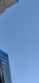 Sky view with crescent moon and city buildings.