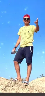 Young man in cap poses on sunny beach under blue sky wallpaper.