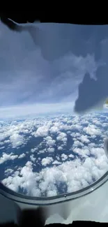 View from airplane window showing clouds and blue sky.