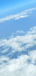 A serene airplane window view with blue sky and fluffy clouds.