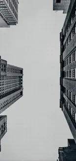 Monochrome view of tall urban buildings against a gray sky.