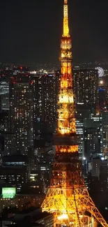 Tokyo Tower glowing at night with city lights backdrop.