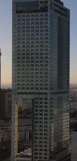 Mobile wallpaper of a modern skyscraper and urban skyline at dusk.