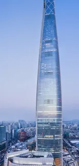 A majestic skyscraper towers over the urban skyline with a clear blue sky.