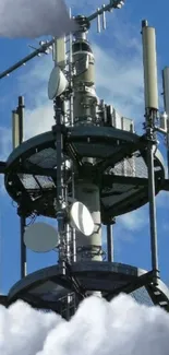 Antenna tower surrounded by clouds and blue sky.