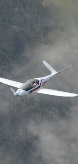 Sleek airplane flying through cloudy sky, showcasing aerial view.