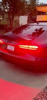 Sleek Audi with glowing taillights at dusk.