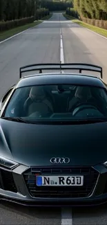 Sleek black Audi R8 on a wide open road.