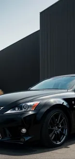 Sleek black car parked by modern industrial building.