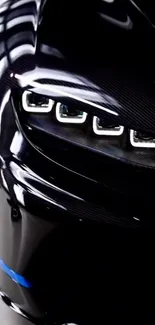 Front view of a sleek black car with striking headlights.