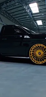 Black car with golden rims in a garage.